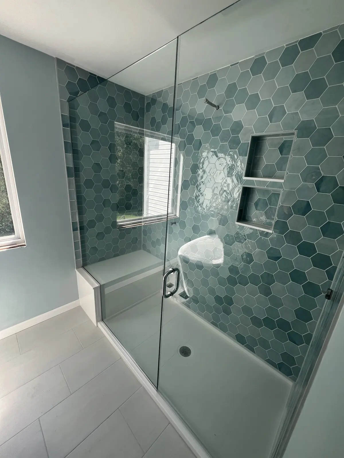 Walk-in shower with teal hex tile, by KM Contracting