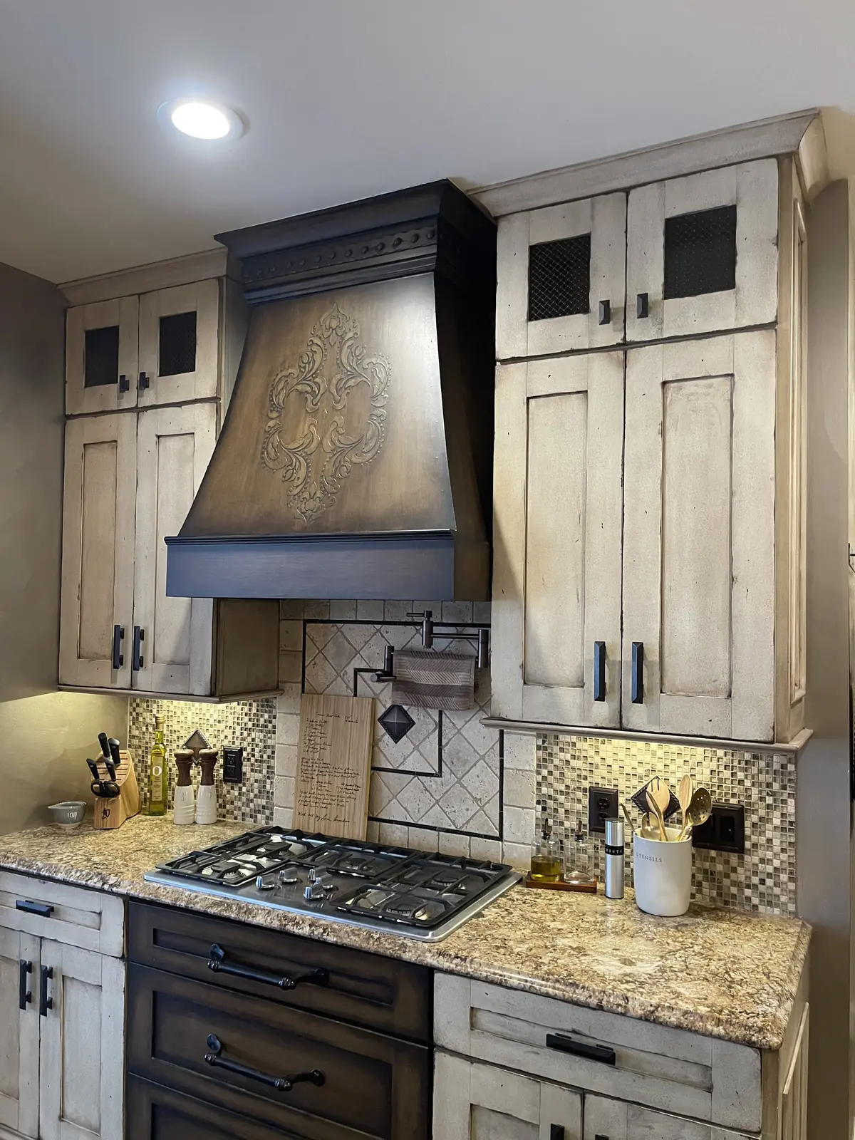 Custom range hood and distressed cabinetry